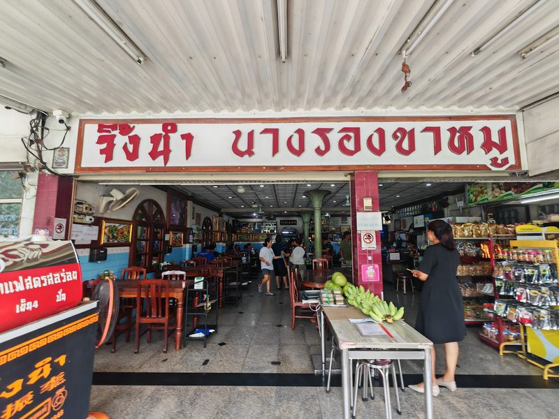 หน้าร้านเปิดโล่งใต้ป้าย จิ้งนำ นางรองขาหมู มองเห็นโต๊ะในร้าน